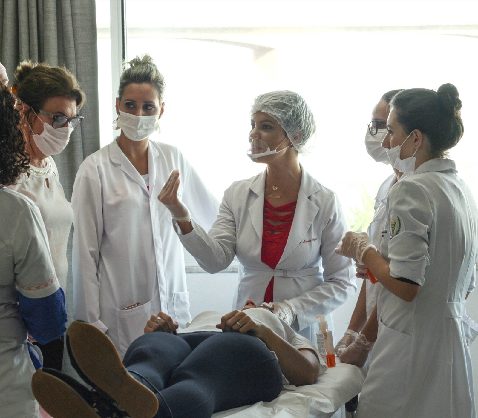 Dra. Marcela avaliando uma paciente em mentoria clínica, com alunas observando