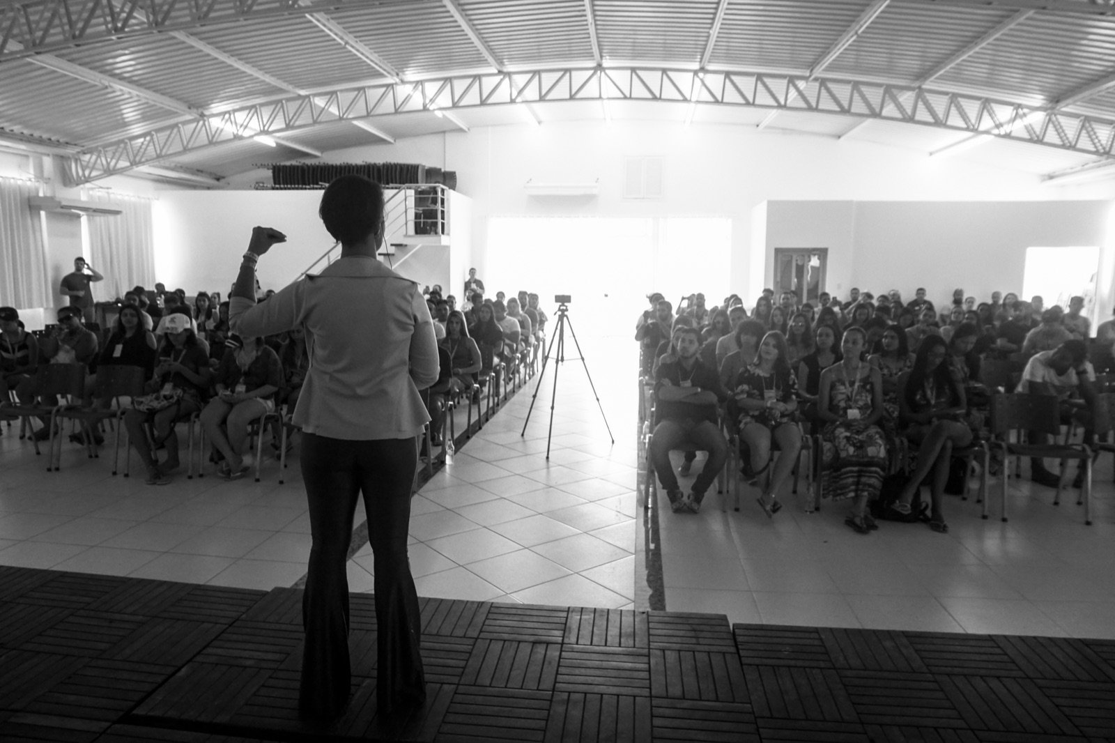 Turma reunida em auditório durante imersão, com a Dra. Marcela ao palco
